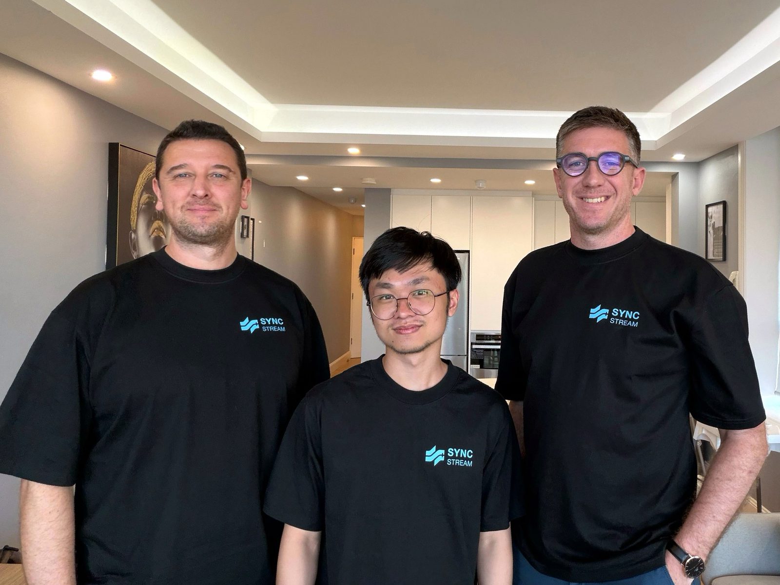 The three Sync Stream founders standing together in matching black Sync Stream t-shirts